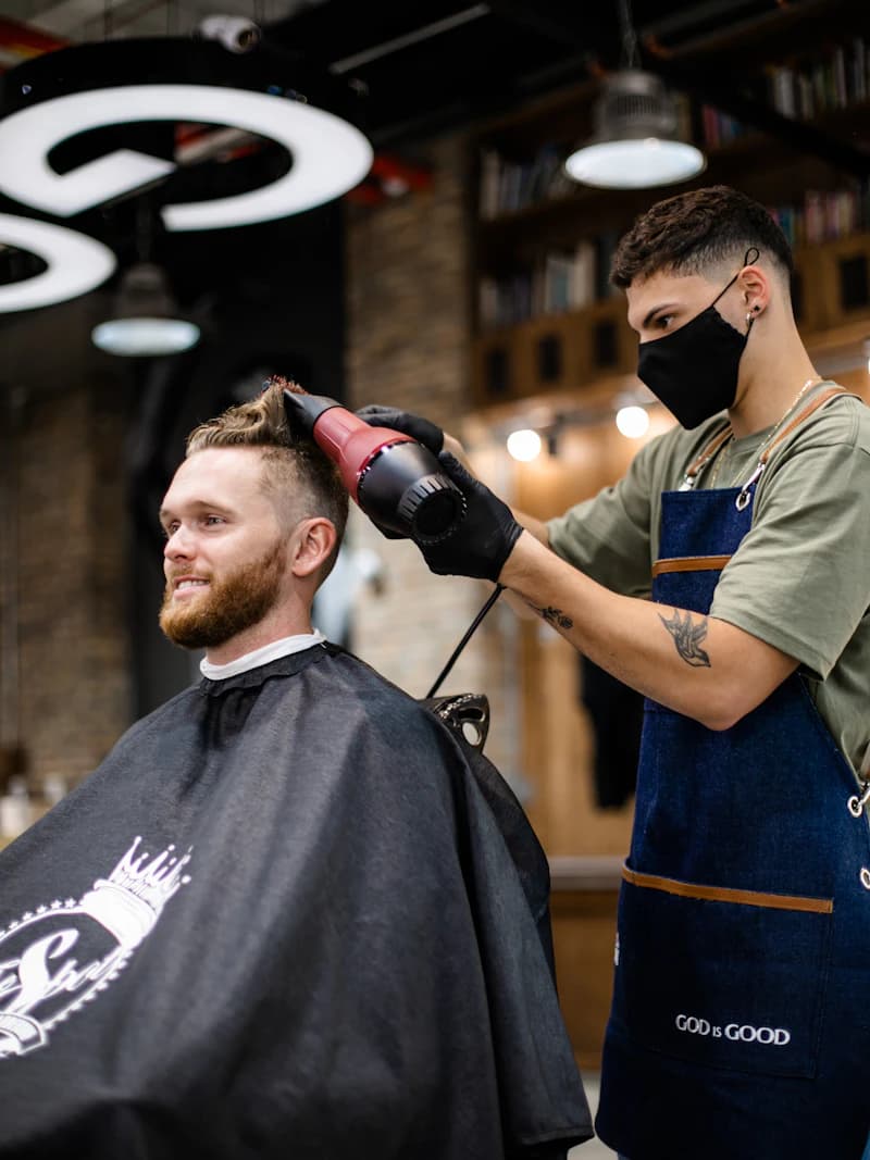 Barbero secando el pelo a un cliente en una barbería
