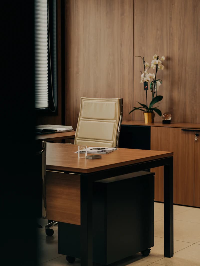 Despacho de una gestoría, con mesa de madera y flores